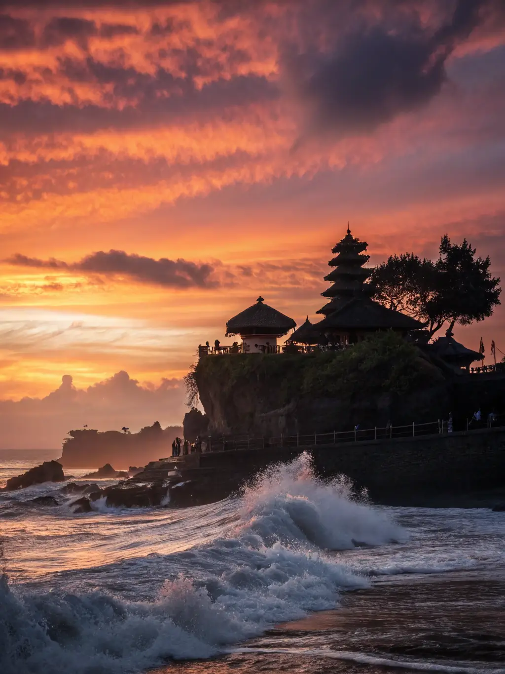 A serene image of the Tanah Lot Temple at sunset, showcasing the temple's silhouette against the vibrant sky, capturing the spiritual and scenic beauty of Bali.